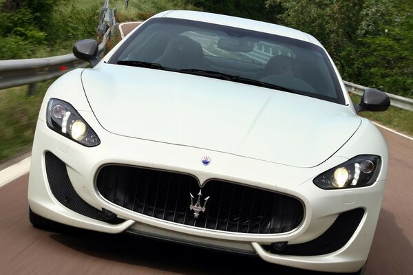Белый спортивный автомобиль maserati мчится подруги